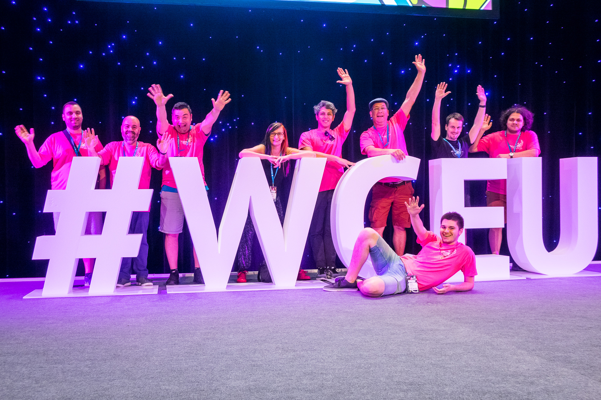 Organisers from WCEU 2019 pose with large #WCEU on stage.