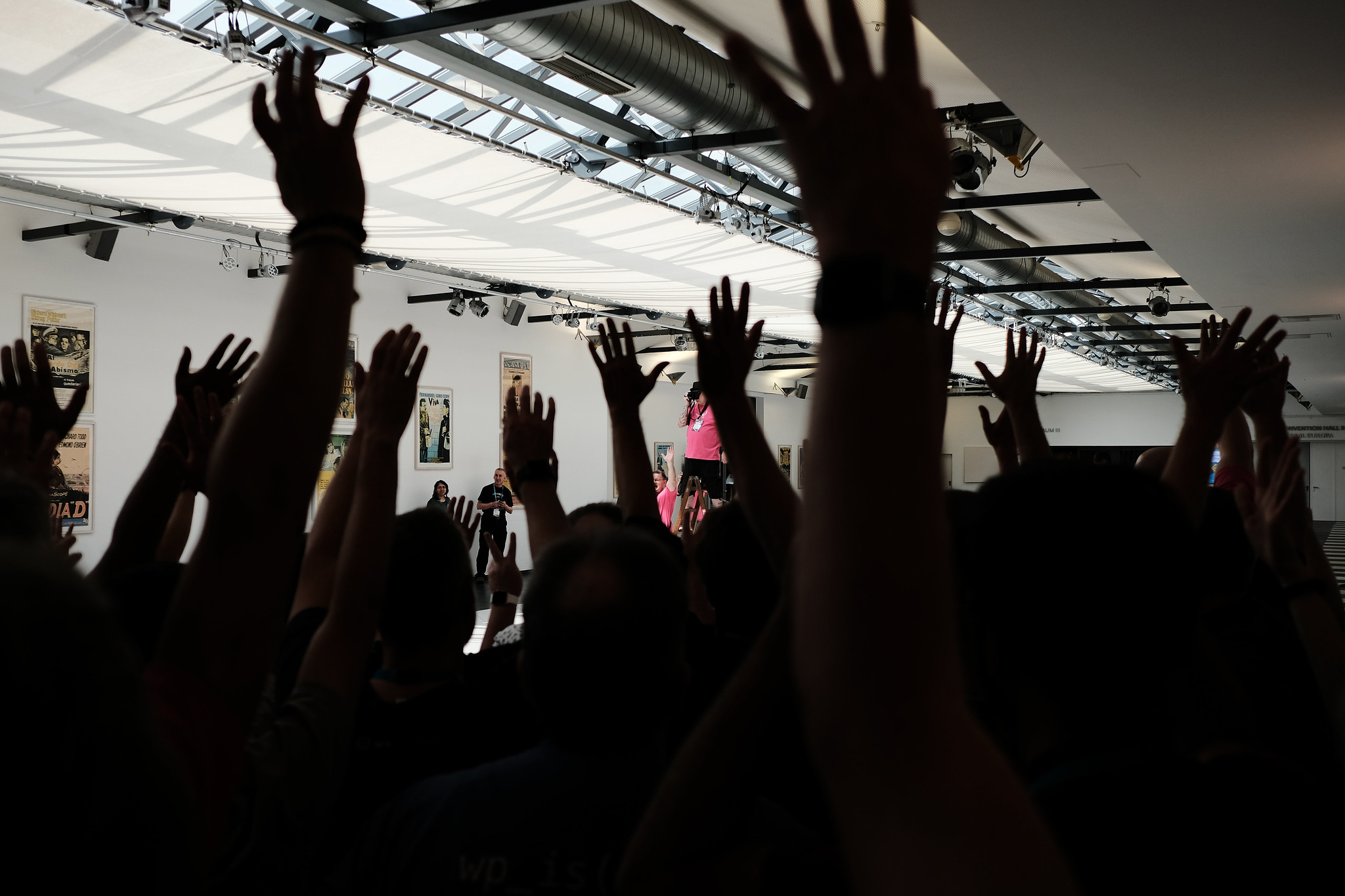 WCEU 2019 attendees raise their hands.