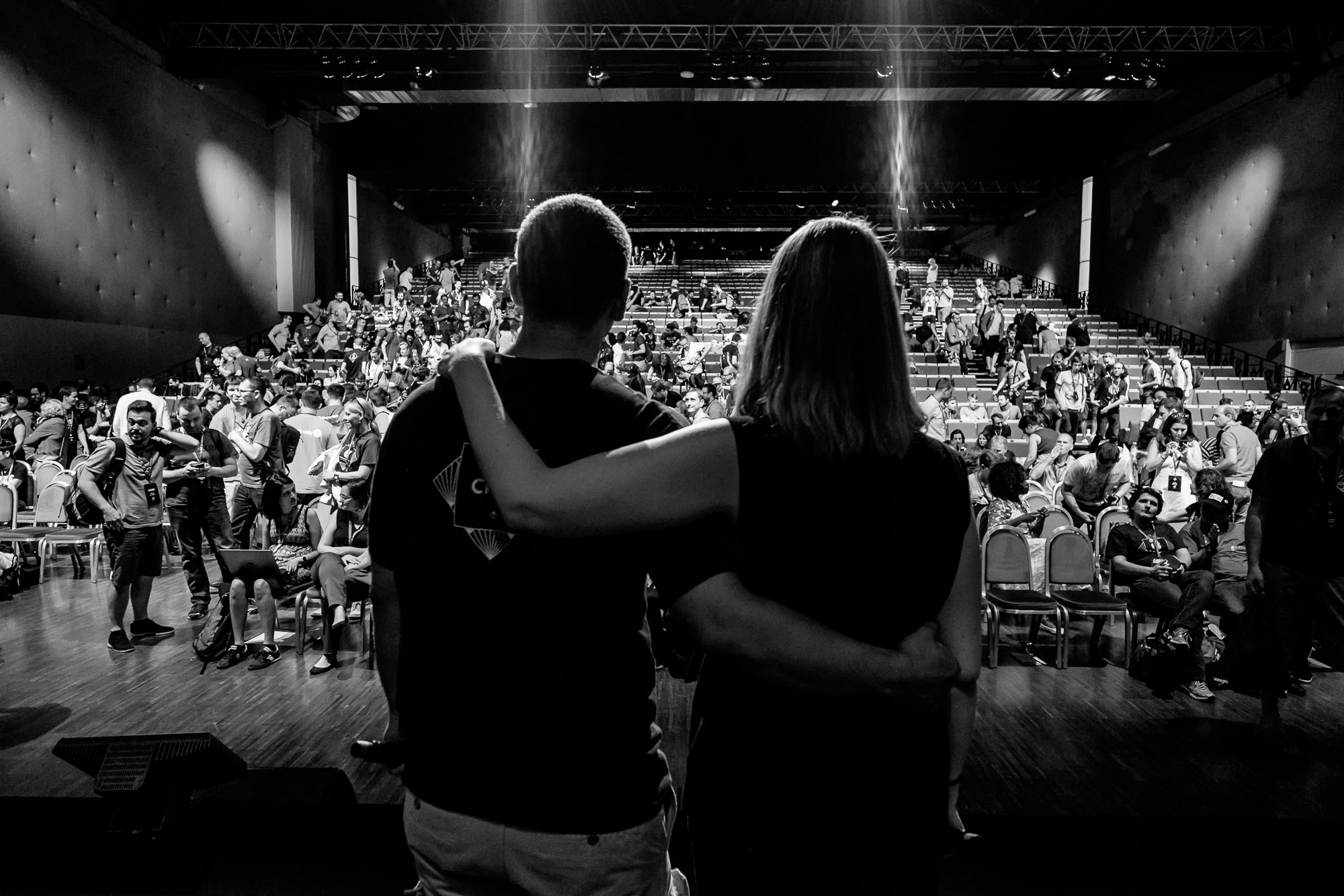 Two people stand, arm in arm, on stage at WCEU.