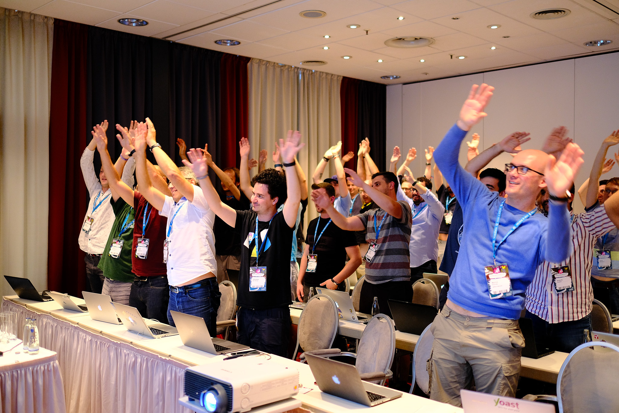 Session attendees with their hands up at WCEU