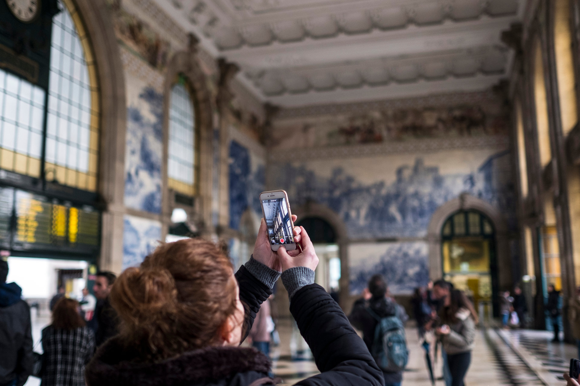 A person taking a photo of the São Bento Station