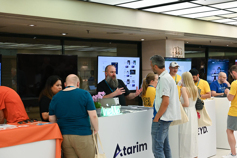 People at a WordCamp Europe Sponsor's stand